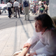 A former comfort woman crouches down on a Tokyo street corner during a protest march on the 50th anniversary of the end of World War II.